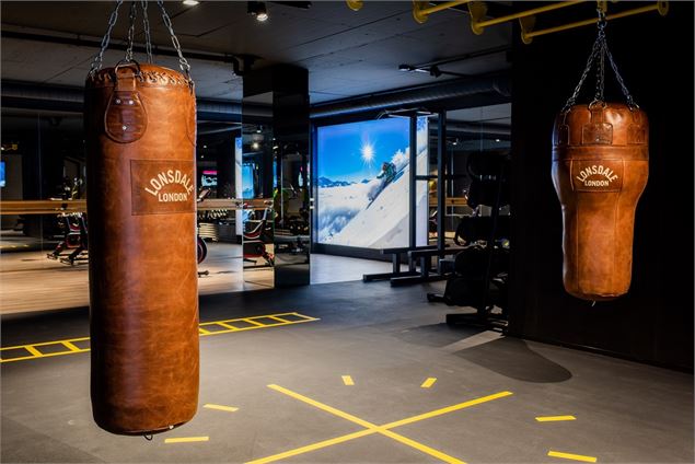 Modern gym facility with boxing bags and training equipment